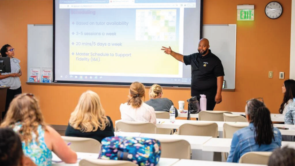 Photo of a man presenting tutoring information to teachers.