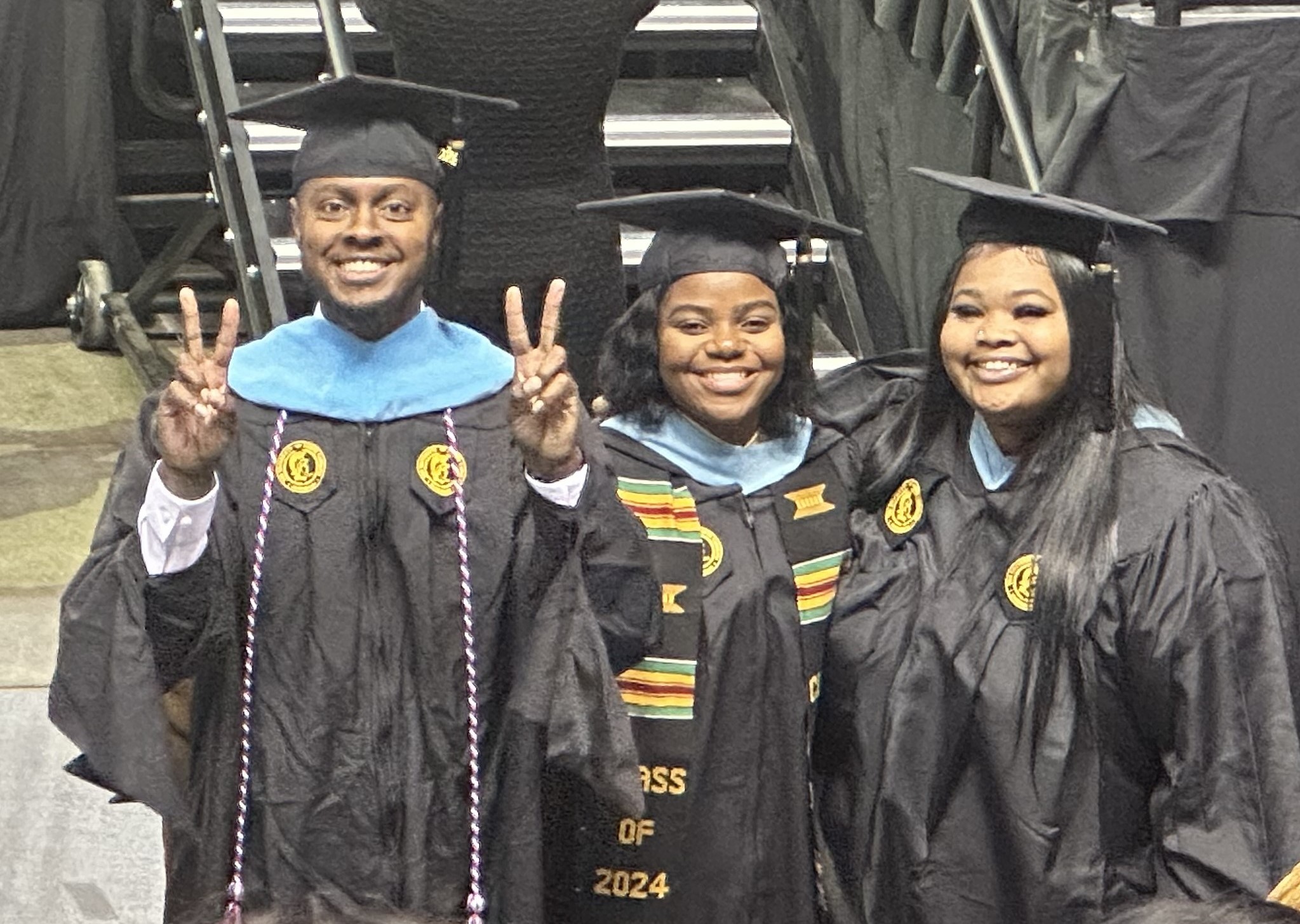 Three students in the MST2 program pose for a photo at their graduation commencement.